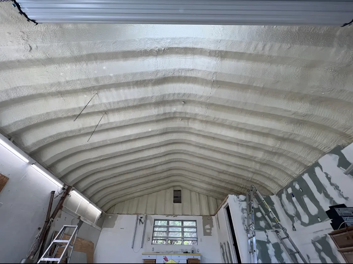 Spray polyurethane foam applied to the underside of a metal roof deck in Holiday